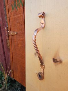 a door handle on a wooden door that is rusted and has been painted gold