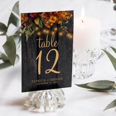 a table number with candles and flowers on it