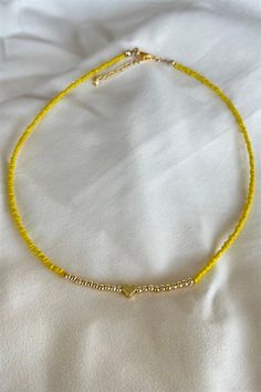 Basic Description: Great simple piece for every occasion. Handmade assorted yellow seed beaded necklace. With gold color heart figure detail. Very lightweight and dainty. Necklaces are joined with a lobster-style clasp and two inch extended chain.  Sizing:  Each necklace is made with a two inch extender chain so the size can be adjusted to your liking. For example, the 16 inch necklace can be extended up to 18 inches. Care: While necklaces will not be damaged by moisture, avoid getting your necklace wet to prevent potential fading or tarnishing. Yellow Seed Bead Necklace, Yellow Beaded Necklace, Seed Beaded Necklace, Dainty Necklaces, 16 Inch Necklace, Yellow Necklace, Color Heart, Seed Bead Necklace, Colorful Heart