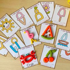 several pictures of different shapes and letters on a table with scissors, pencils, and paper clips