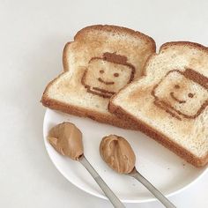 two slices of toast with peanut butter on them and the faces of people drawn on them