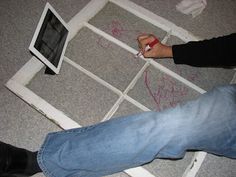 a person sitting on the floor drawing with chalk