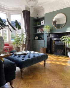 a living room filled with furniture and a fire place next to a large potted plant