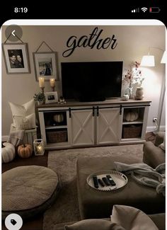 a living room with a large tv and pictures on the wall above it's entertainment center