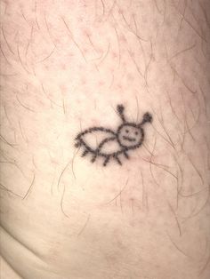 a small tattoo on the side of a person's leg that has an insect drawn on it