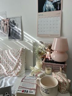 a table topped with lots of items next to a lamp and pictures on the wall