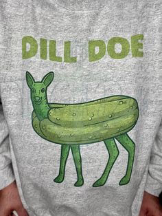 a person wearing a sweatshirt that has a pickle on it and the words dill doe written in green