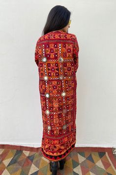 Long Boho Patchwork Quilted Festival Coat from AlMiro The most rarest piece of our collection! Stunning up-cycled coat dyed in red orange shade, handmade from authentic tribal Indian Banjara vintage fabric. This fabric was created by the ancient nomadic tribes of north India. The Banjara people are believed to have descended from European gypsies thousands of years ago, which would explain its cool boho look. With a hand embroidered design, two side pockets and side slits, this one of a kind jac Long Outerwear With Resham Embroidery For Festivals, Patchwork Kimono Sleeve Outerwear For Festival, Festival Outerwear With Patchwork And Kimono Sleeves, Long Kurta With Mirror Work For Festivals, Bohemian Style Kimono With Traditional Patterns For Festivals, Bohemian Kimono With Traditional Patterns For Festival, Bohemian Kurta With Resham Embroidery For Fall, Festival Kimono With Long Sleeves, Bohemian Resham Embroidered Kurta For Fall