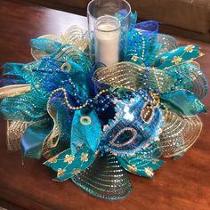 a candle sits on a table next to a blue and gold corsage decoration