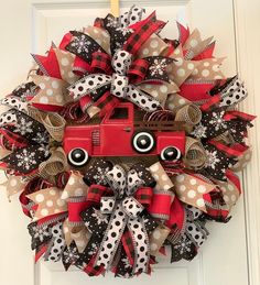 a wreath with a red truck and polka dot ribbon on the front door to give as a decoration