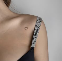 a woman with a heart tattoo on her shoulder