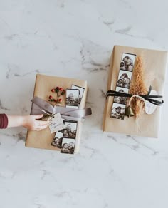 two small boxes with pictures on them sitting on a marble counter top next to each other