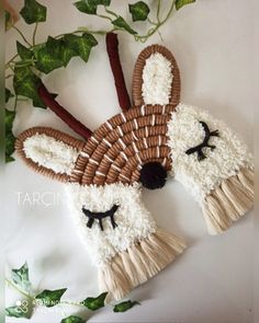 an animal made out of straw and yarn with fake leaves around it's eyes