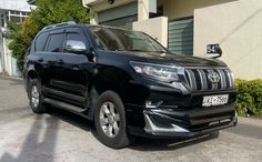 a black toyota land cruiser parked in front of a building