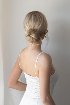 a woman in a white dress is looking out the window with her back to the camera