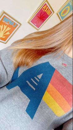 a woman with long blonde hair is wearing a sweatshirt that has an airplane on it