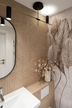 a white sink sitting under a bathroom mirror next to a wall mounted faucet