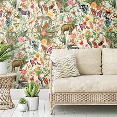 an animal themed wallpaper in a living room with sofa and potted plants on the floor