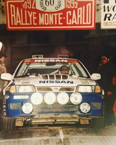 a man driving a rally car through a garage