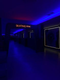 the entrance to skatating rink is lit up with blue lights and neon signs