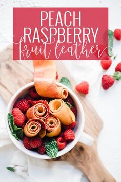 a bowl filled with fruit on top of a wooden cutting board next to strawberries