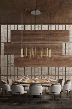 a dining table with white chairs in front of a wooden paneled wall and chandelier