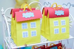 two small paper bags sitting on top of a metal rack filled with candy bars and candies