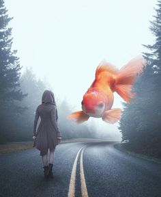 a woman is walking down the road towards a goldfish