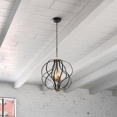 an industrial style chandelier hanging from the ceiling in a room with exposed brick walls