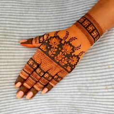 a woman's hand with hennap and flowers painted on the palm,