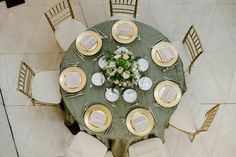 an overhead view of a table set with white and gold plates