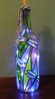 a colorful glass bottle with dragonflies on it