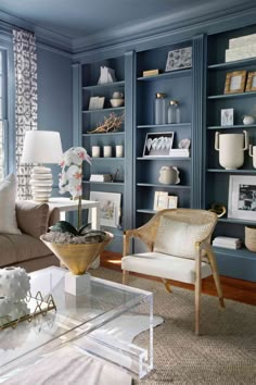 a living room filled with lots of furniture and bookshelves covered in blue paint