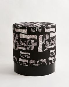 a black and white patterned stool on a white background with the word love spelled in cursive letters