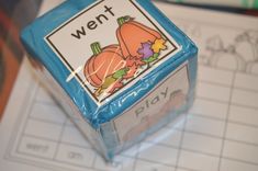 a close up of a plastic container on a table with writing paper and pumpkins