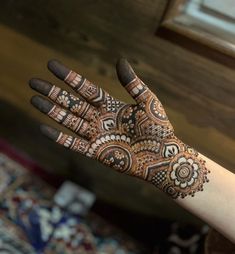 a woman's hand with henna tattoos on it