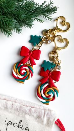 two christmas candy lollipopo earrings on a white surface