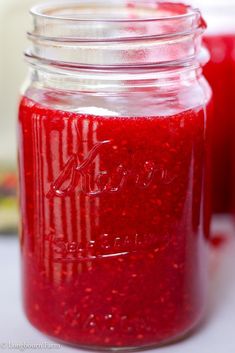 two jars filled with red liquid sitting on top of a table