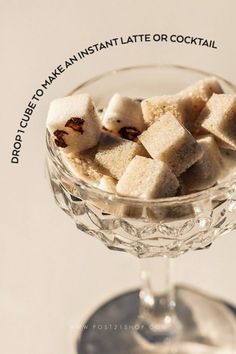 a glass bowl filled with sugar cubes on top of a table