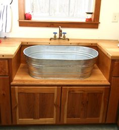 a large metal tub sitting on top of a wooden counter