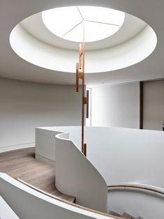 the interior of an office building with curved staircases and circular skylight above it