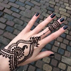 a woman's hand with henna tattoos on it