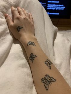 a woman's arm with small tattoos on it