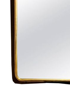 a gold framed mirror sitting on top of a white wall