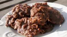 chocolate cookies on a white plate sitting on a wooden table