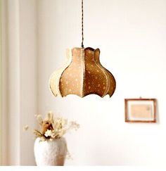 a vase filled with flowers sitting on top of a table next to a light fixture