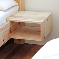 a bed with a wooden side table next to it