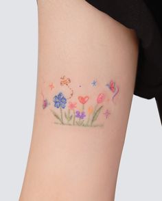 a woman's thigh with flowers and butterflies painted on it in the shape of a heart