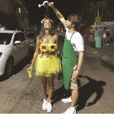 a man and woman dressed up in costumes standing next to each other on the street