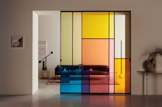 a living room with an open door that has multicolored glass panels on it